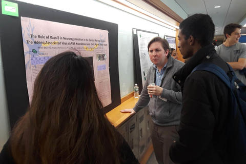 faculty member discussing a students poster