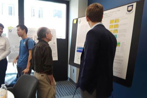 faculty member viewing students poster