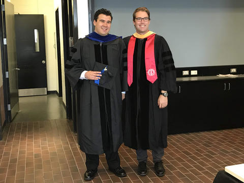 graduate posing with faculty advisor