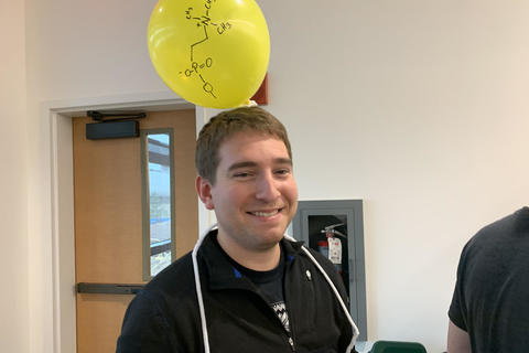 person with a ballon on his head with a cell equation
