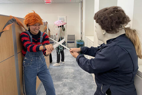 2 people in costume chucky from chucky movies fighting michael myers from halloween movie